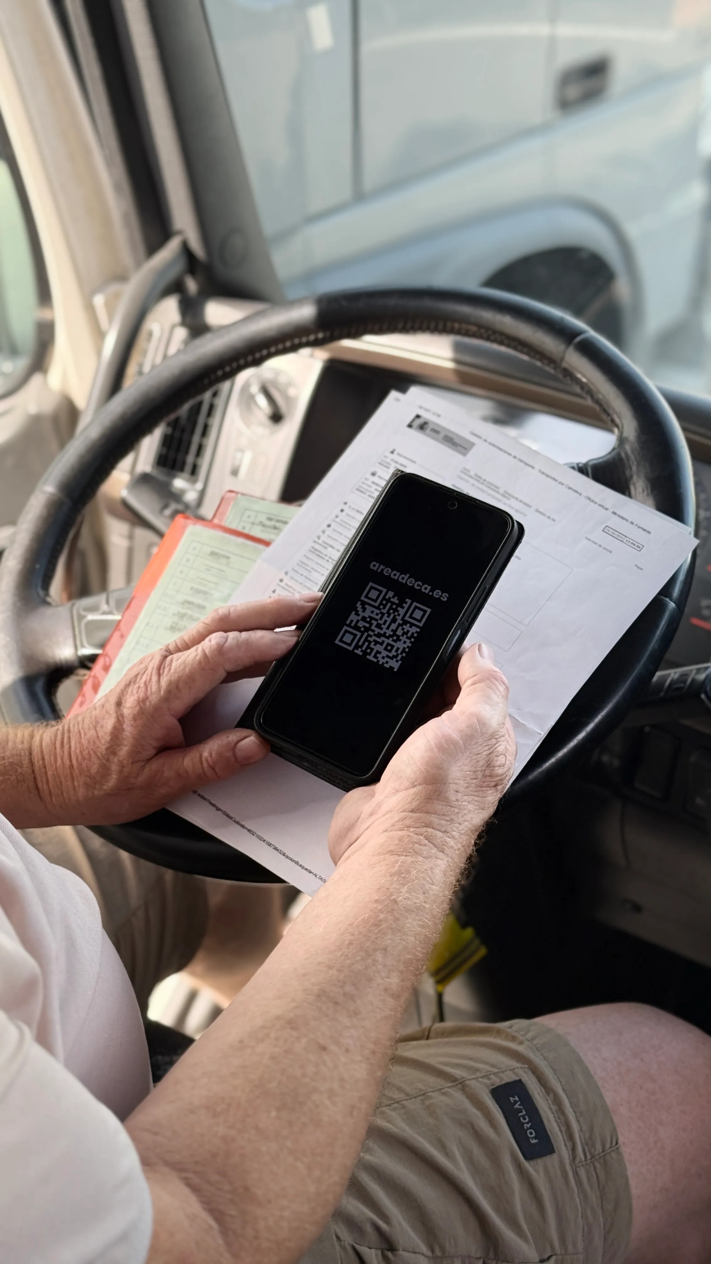 Conductor mostrando un QR en el teléfono móvil